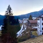 Foto che raffigura scorcio di Dosoledo. case e alberi in primo piano