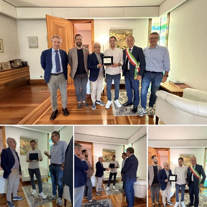 Foto con gruppo di persone in ufficio e consegna targa in argento